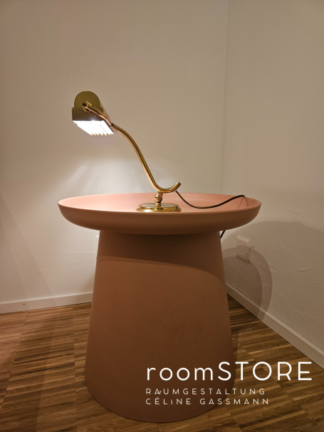 Art deco Klavierlampe 130.- Ein runder, terrakottafarbener Tisch mit einer eleganten, gebogenen Lampe.